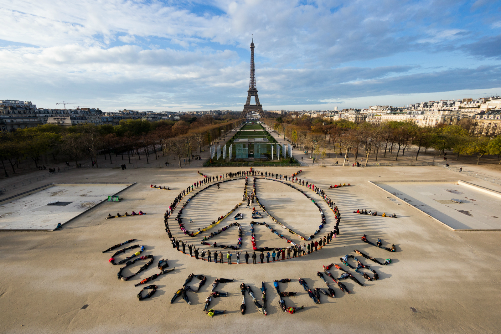 activists spelling "100% renewable" with their bodies in front of Eiffel Tower