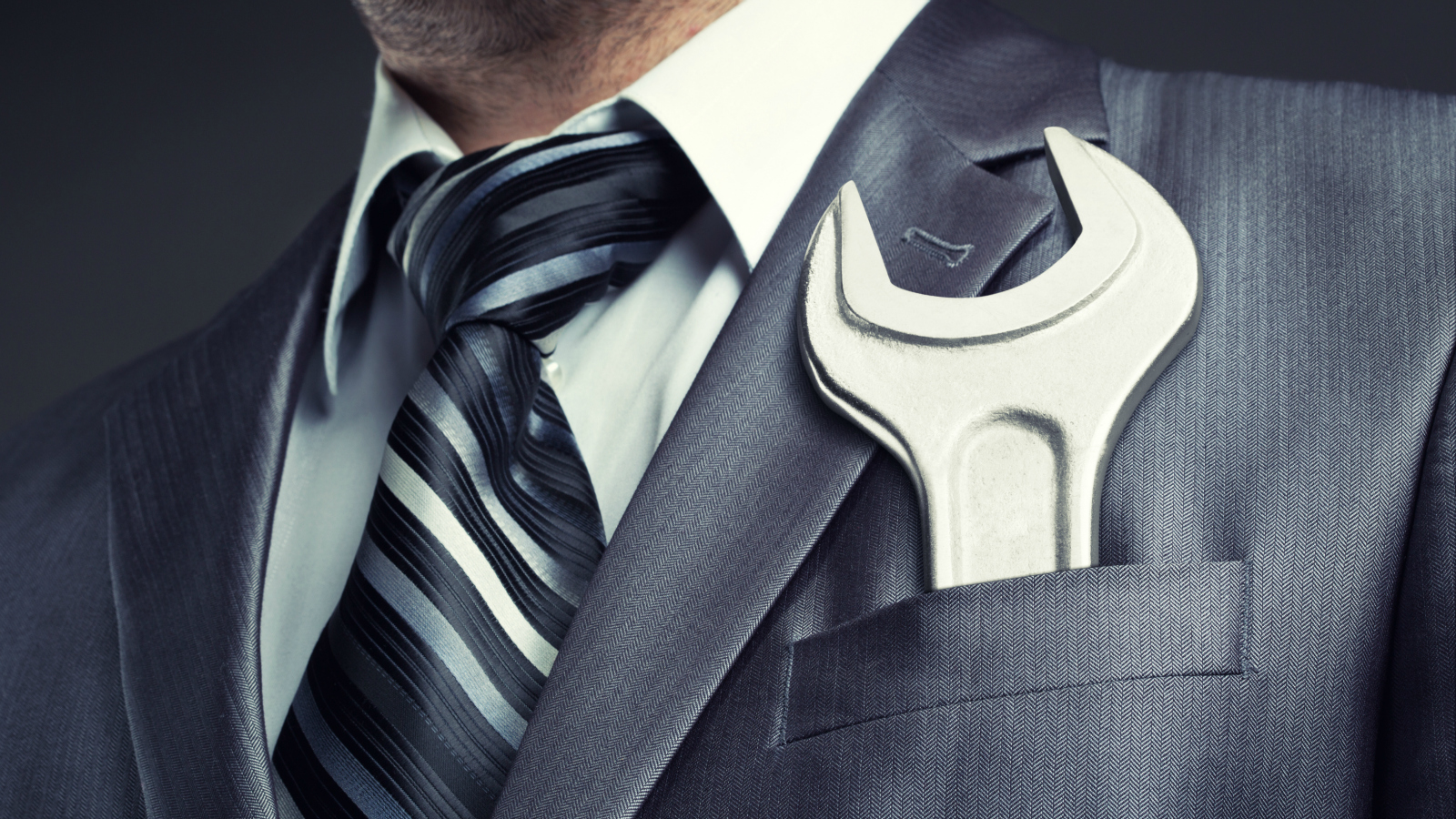 suited man with wrench in pocket