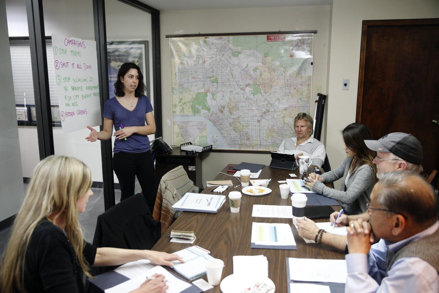 Alexandra Nagy, an organizer with Food & Water Watch, speaks about a plan to "Shut It All Down" as residents including Matt Pakucko, president and co-founder of Save Porter Ranch, center right, and Kyoko Hibino, rear right, look on, during a board meeting for the group on Jan. 3.