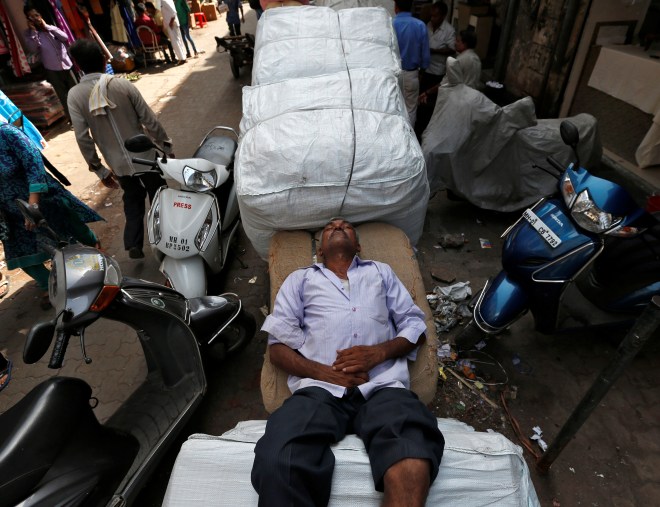 A labourer rests on a handcart on a hot summer day in Mumbai, India, May 23, 2016. REUTERS/Danish Siddiqui - RTSFJGW