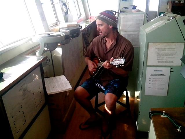 Keith Davis plays his mandolin on the bridge of the Victoria No. 168. Davis had once written a song about observers who died at sea: “Some say he’s lost. Maybe he’s been found.”