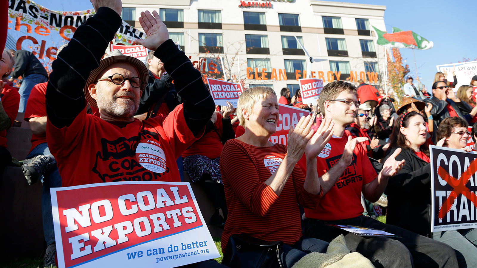 Russ Childers, left, of Seattle, sits among other protesters as they demonstrate against trains carrying coal for export moving through Washington state on Thursday, Oct. 17, 2013, in Tacoma, Wash.