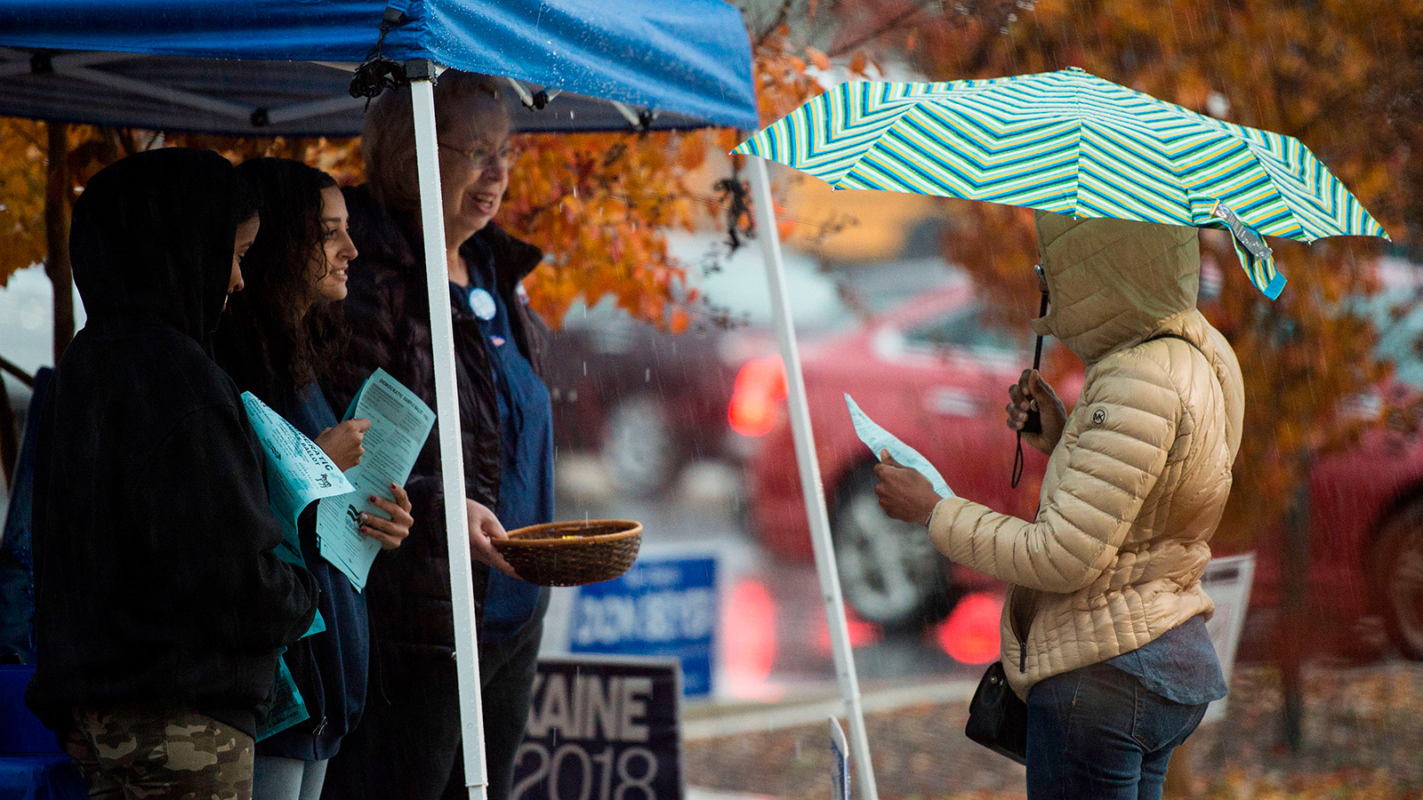 Volunteers with the Democratic party speak to voters outside of a polling station during the mid-term elections at the Fairfax County bus garage in Lorton, Virginia on November 6, 2018.