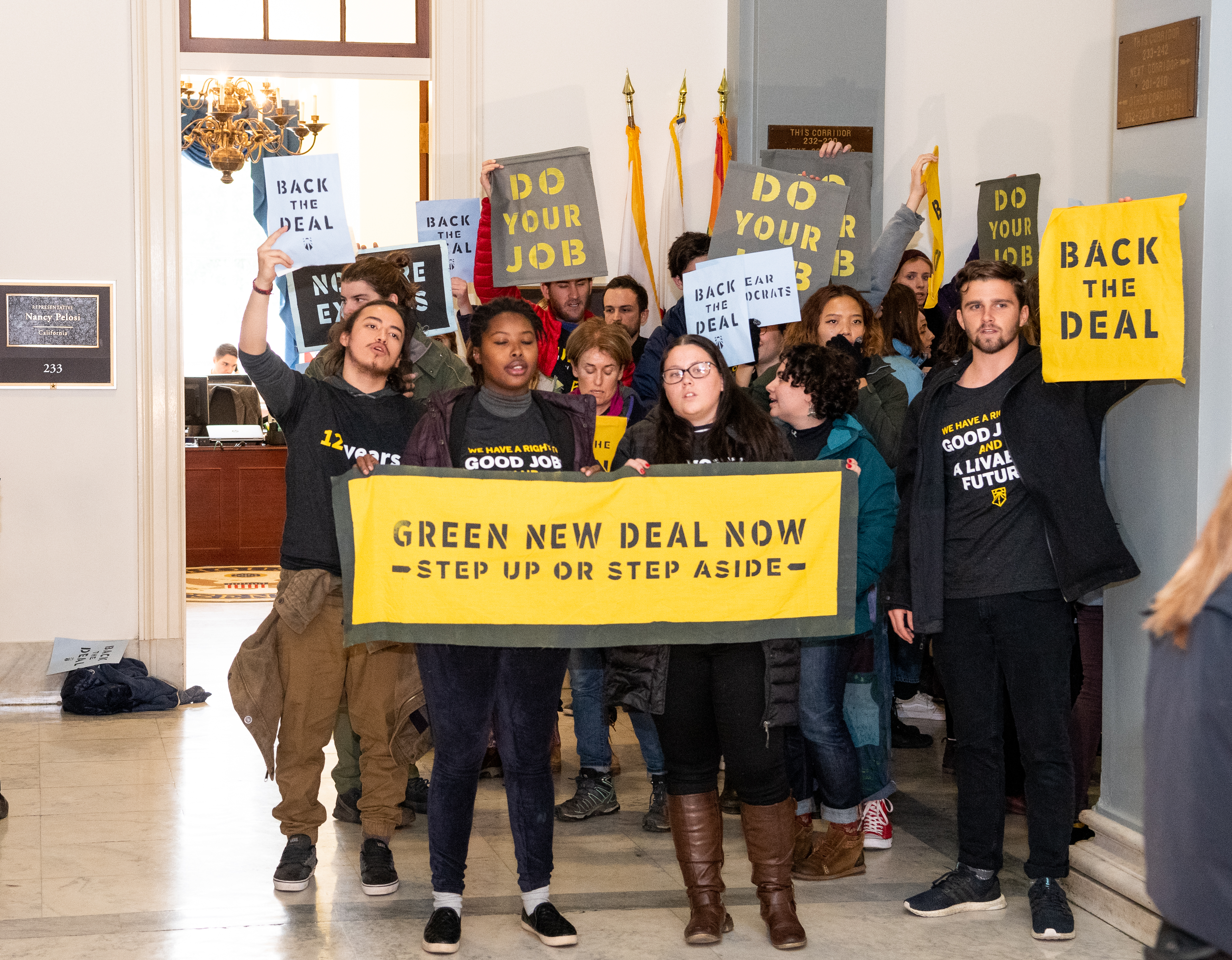 Protesters seen holding placards during the Sunrise Movement protest inside the office of US Representative Nancy Pelosi (D-CA) to advocate that Democrats support the Green New Deal, at the US Capitol in Washington, DC.