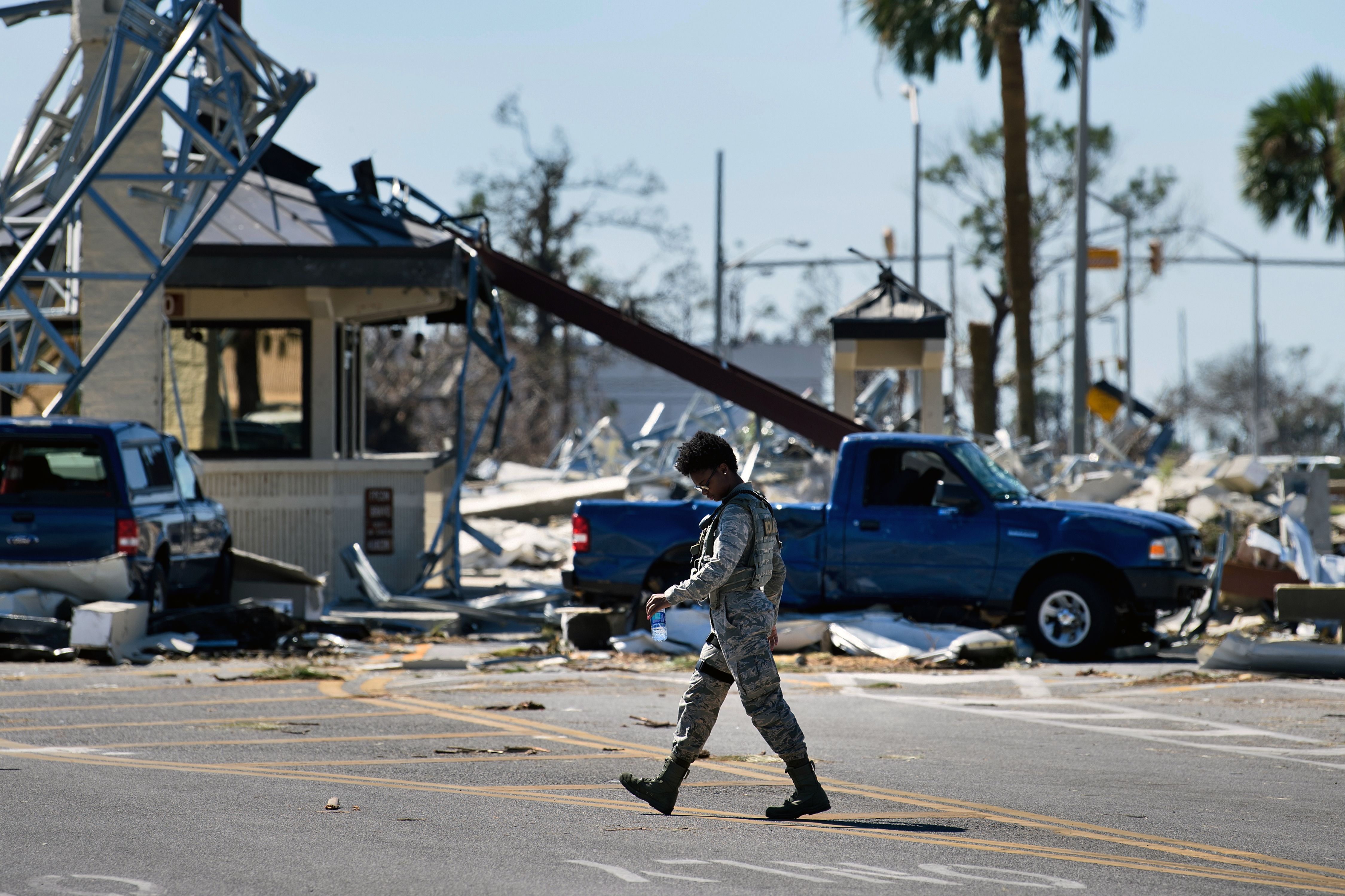 An officer walks near a destroyed gate in Tyndall Air Force Base in Florida, in the aftermath of Hurricane Michael.