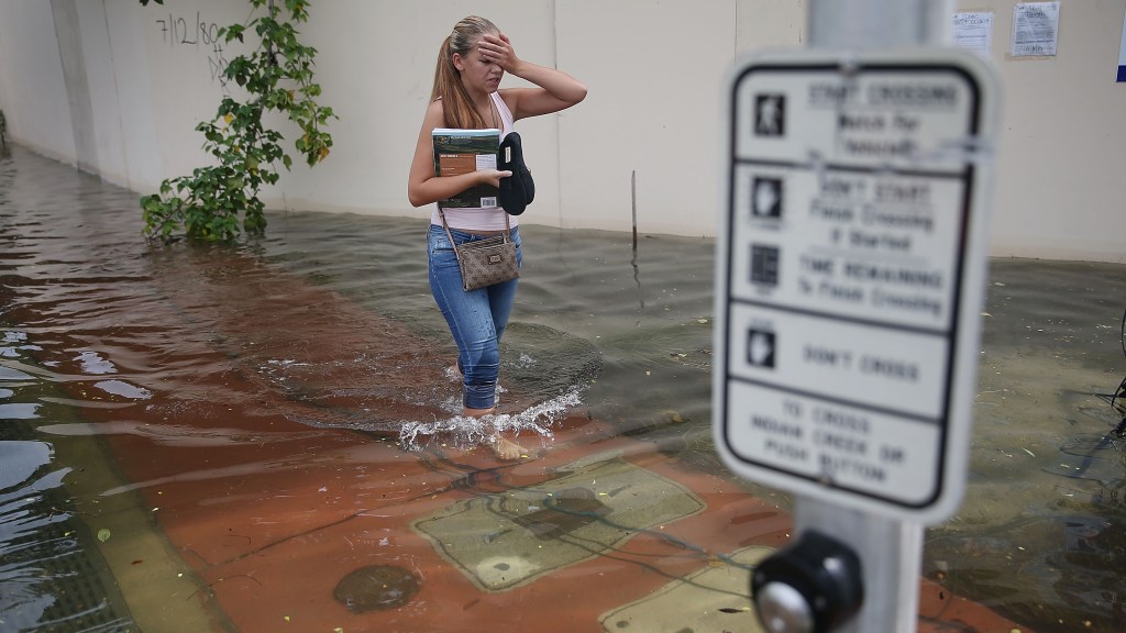 A woman walks through a flooded street in Miami Beach, Florida.
