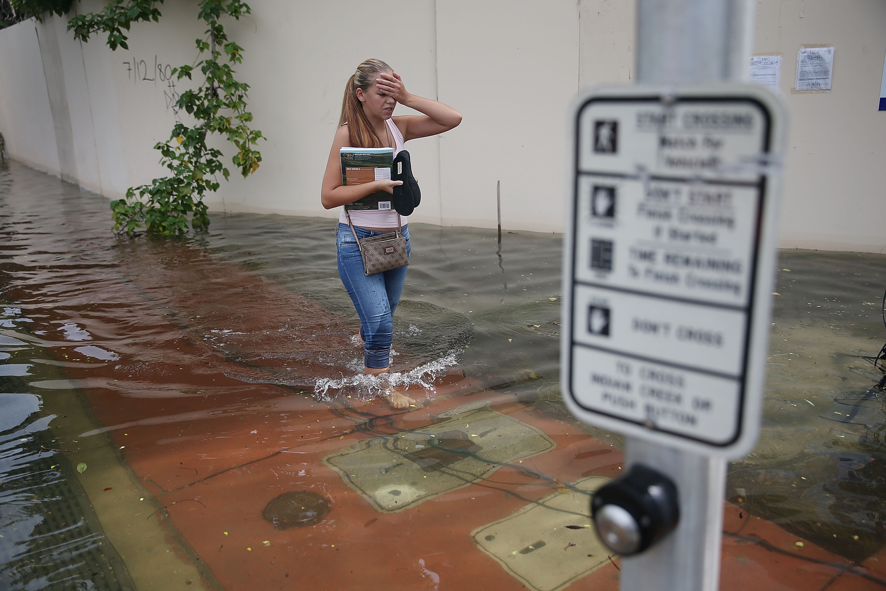 A woman walks through a flooded street in Miami Beach, Florida.