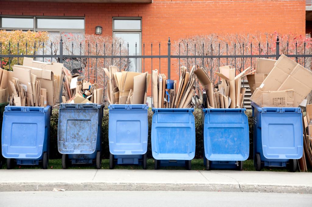 Six recycle bins overflowing with cardboard.