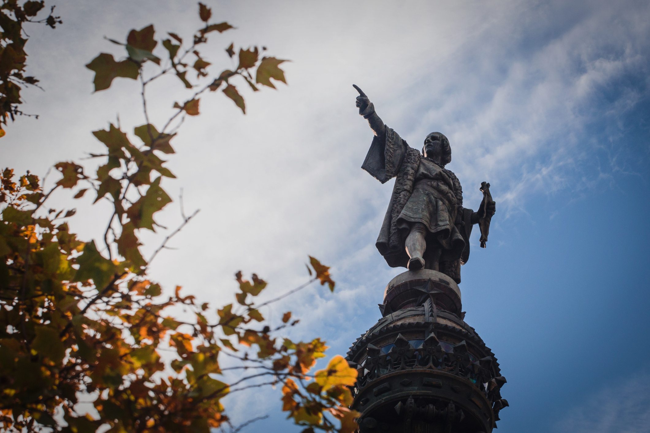 Monument of Christopher Columbus against a cloudy sky.