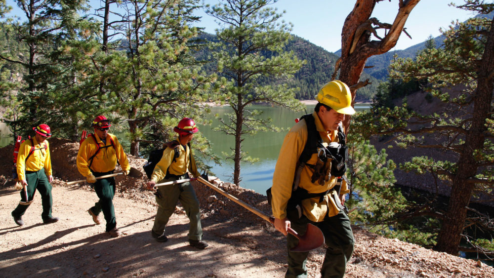 A fire crew hikes past McClure Reservoir in New Mexico en route to conducting a prescribed burn