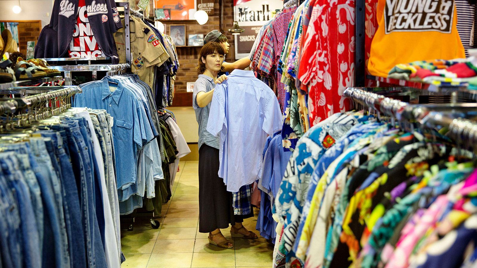A women looks at second hand clothing at a second hand shop in Tokyo, Japan.