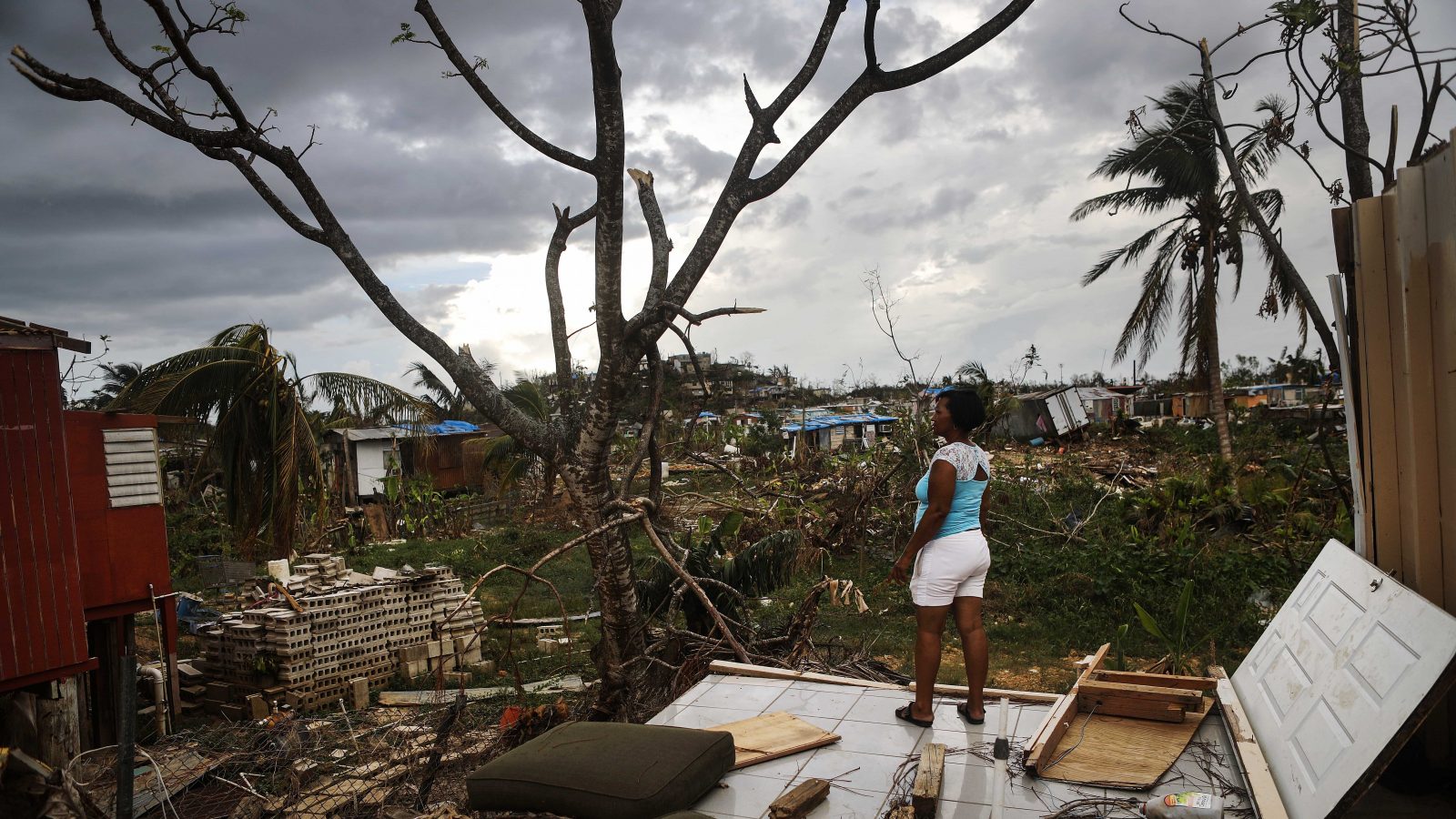 Woman looking at damage after Hurricane Maria.