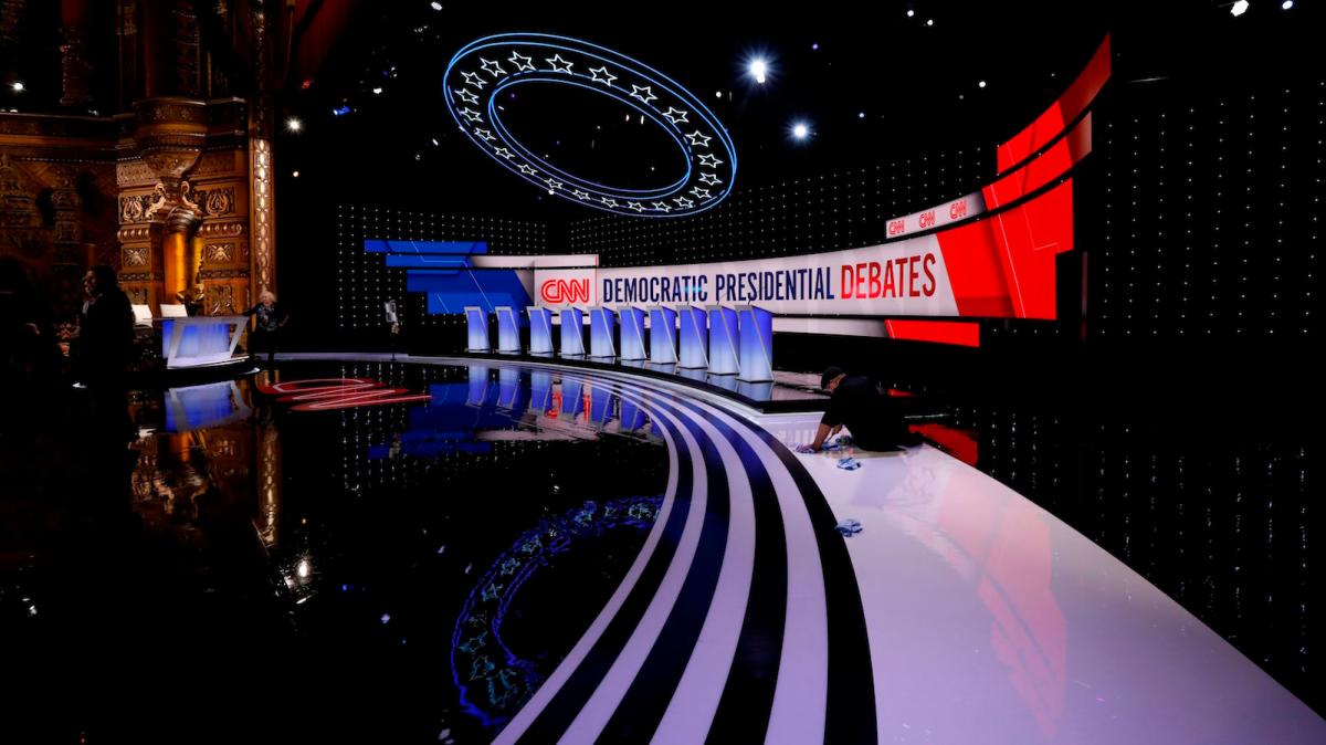 Workers prepare empty debate stage.