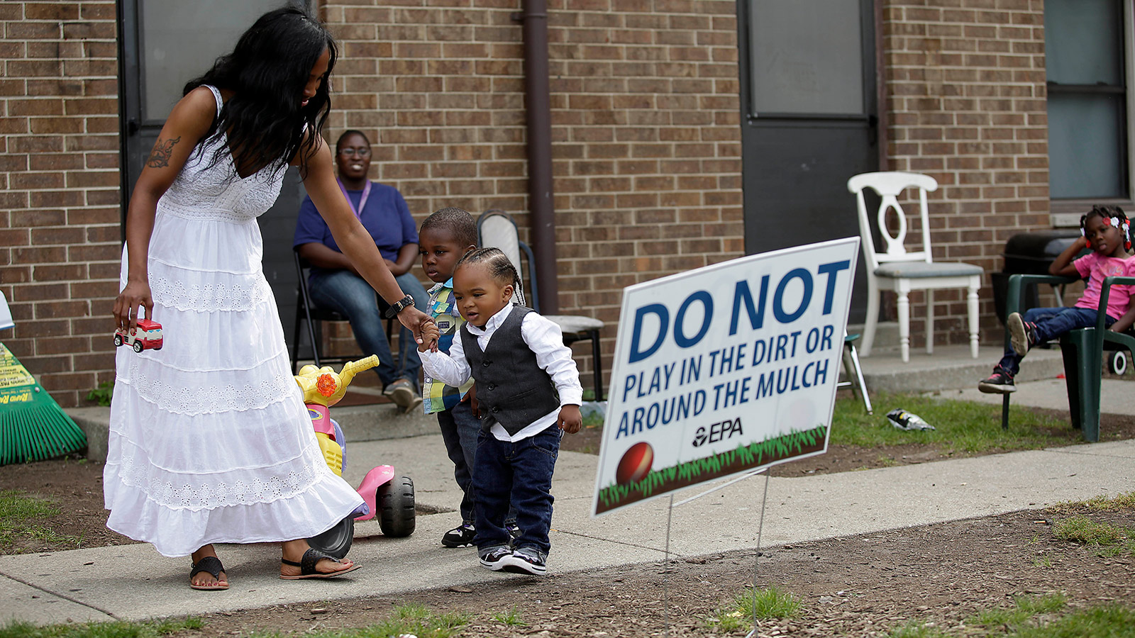 Camica Anderson, left, holds her son Logan Anderson's hand as other residents look on at the West Calumet Housing Complex on September 4, 2016 in East Chicago, Indiana.