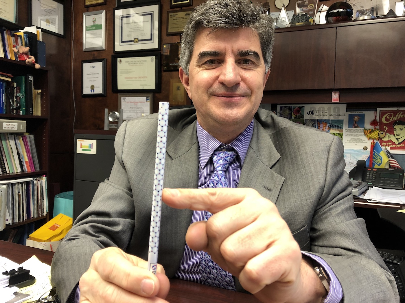 Professor Gogotsi points to a pencil with the molecular structure of carbon nanotubes illustrated on the outside