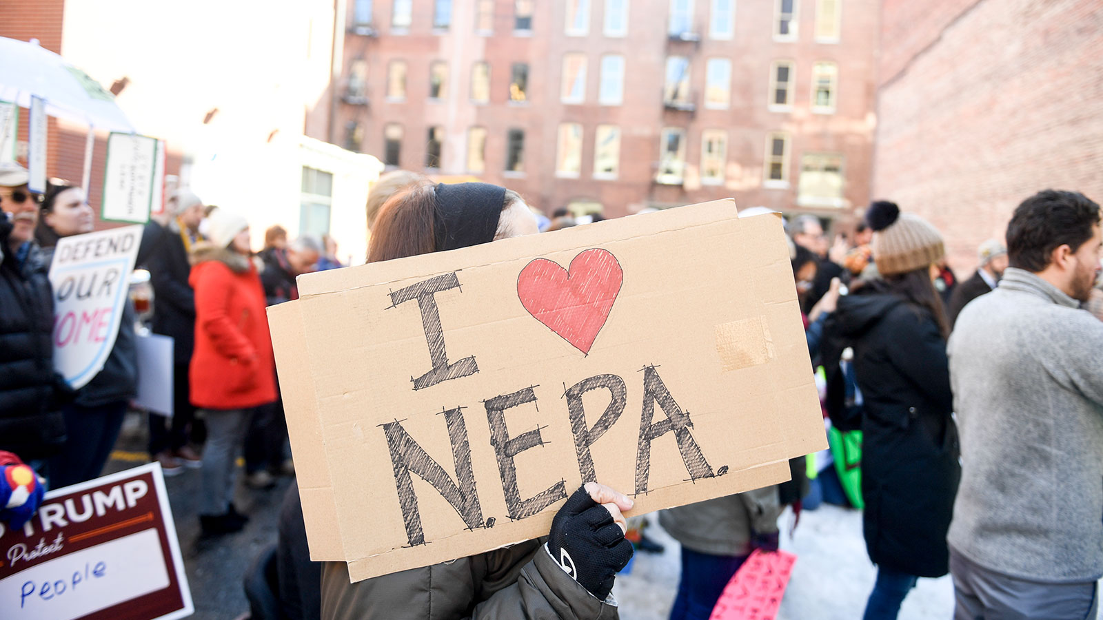 A protester holds up a sign that says "I heart NEPA"