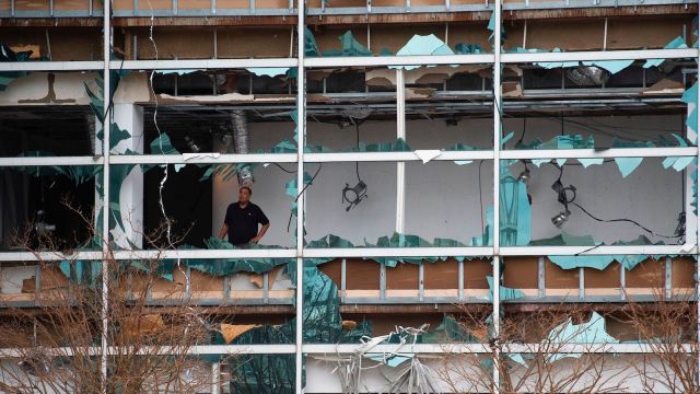 A man looks at damage inside the Capitol One Bank Tower, with its windows blown out in the downtown area after Hurricane Laura passed through