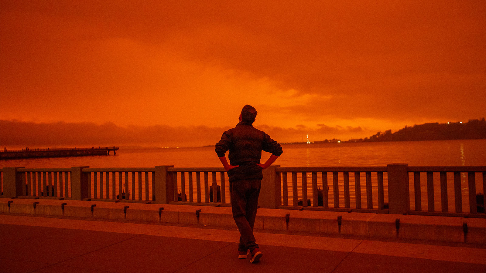 A man stares out at the orange sky in San Francisco, California.