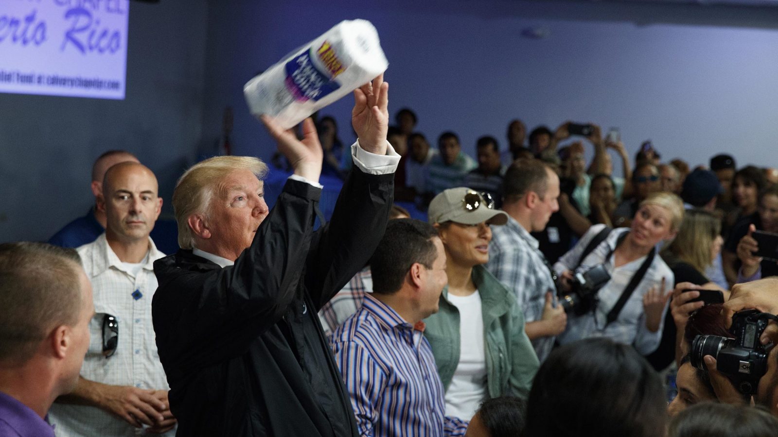 Trump throws a roll of paper towels into the crowd.