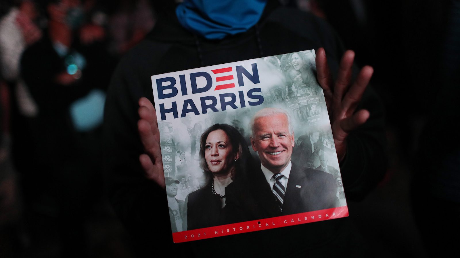 Hands hold calendar showing President-elect Joe Biden And Vice President-elect Kamala Harris