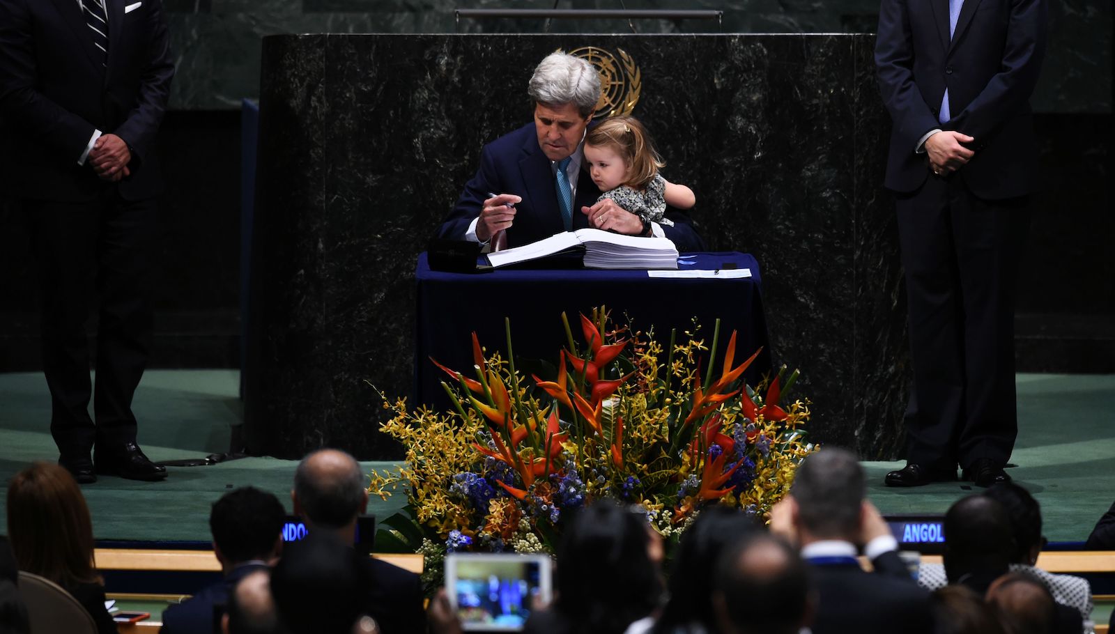 US Secretary of State John Kerry holds his granddaughter, Isabelle Dobbs-Higginson, during the signature ceremony for the Paris Agreement at the United Nations General Assembly Hall in April 2016.