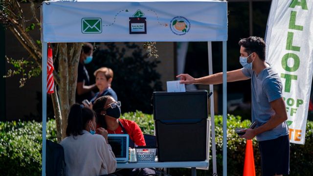 A man dropping off his ballot at an Orange County, Florida voting booth