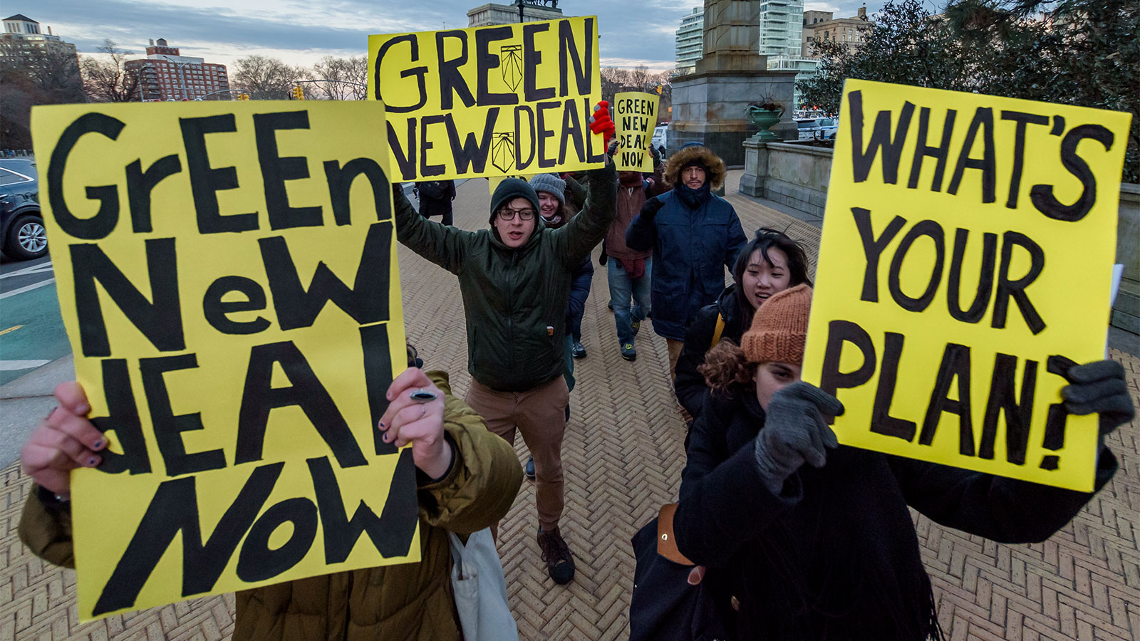 Green New Deal supporters hold signs encouraging action on climate change.