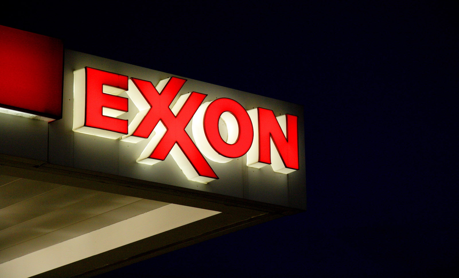 An Exxon gas station sign against a dark night sky