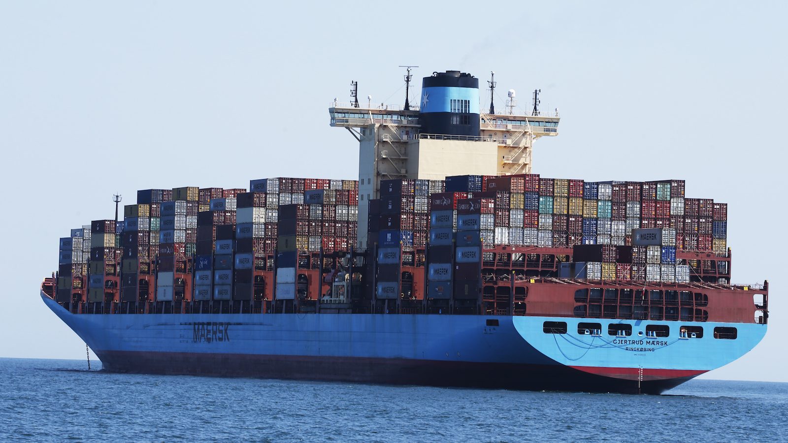 A photo of the container ship Gjertrud Maersk, anchored off the coast of Virginia Beach on June 29, 2020. The large, blue vessel is topped with hundreds of colorful shipping containers