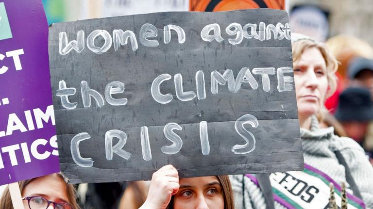 A woman holding a sign that says 