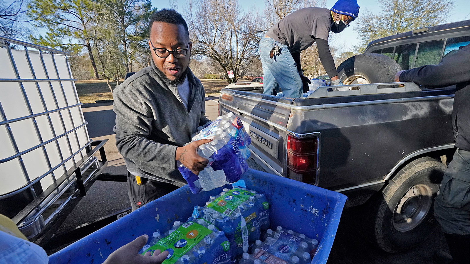 Madonna Manor maintenance supervisor Lamar Jackson left, stacks bottled water brought by Mac Epps of Mississippi Move, as part of the supply efforts by city councilman and State Rep. De'Keither Stamps to a senior residence in west Jackson, Miss.