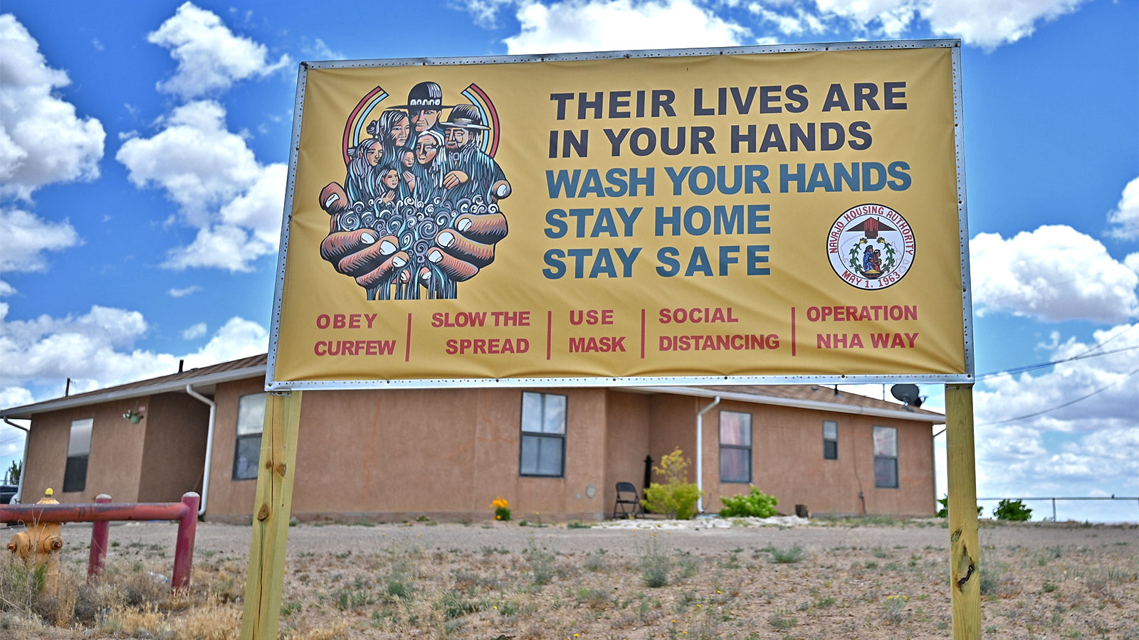 A sign displays a message about staying safe from the coronavirus at an entrance to a Navajo Nation housing community.