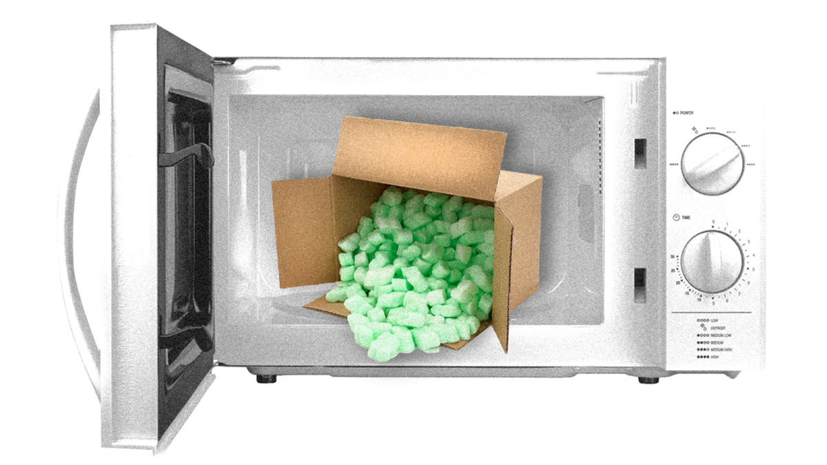 An open microwave with a box of polystyrene packing peanuts in it