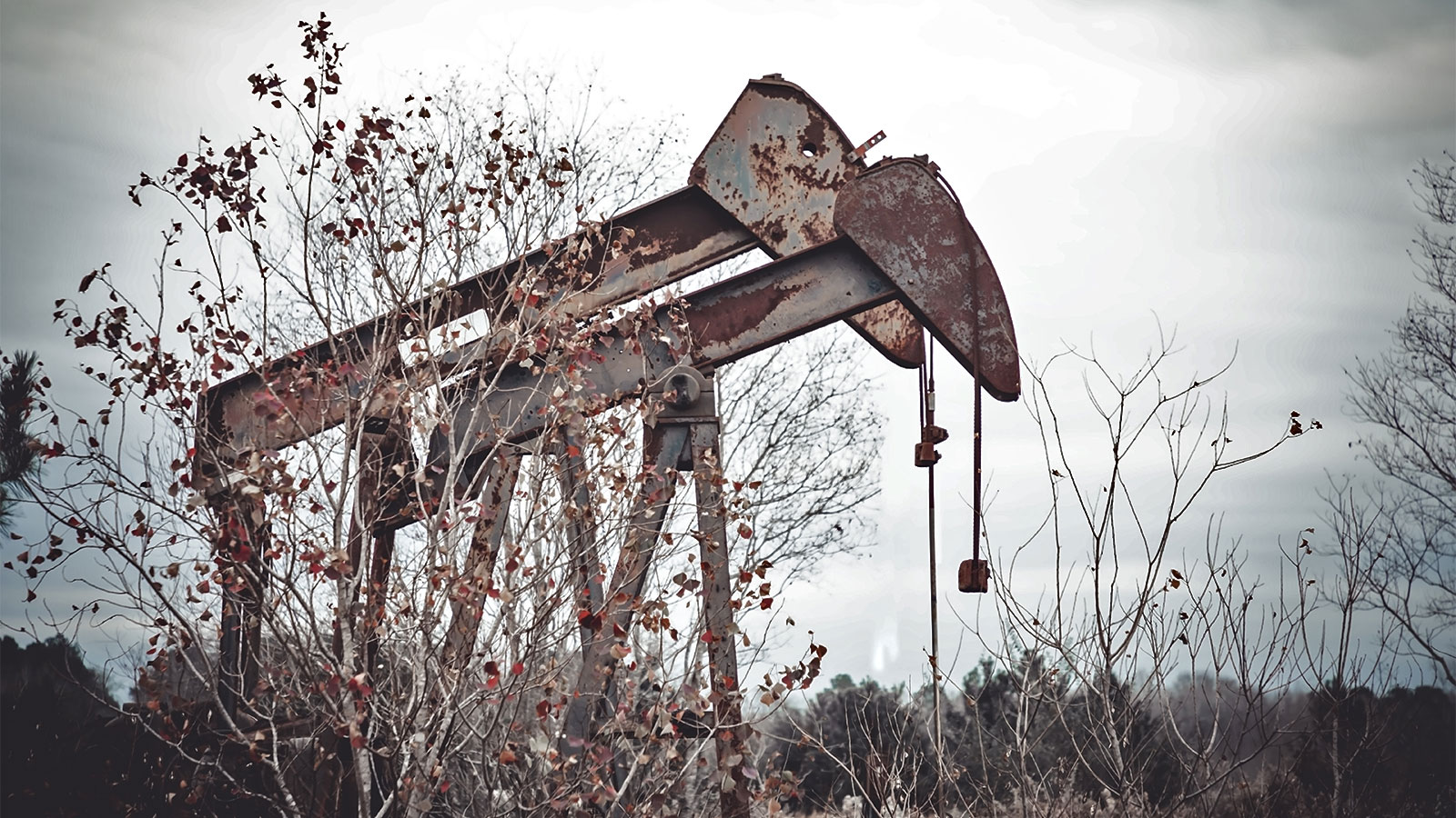 A photograph of rusty abandoned oil pumps in rural Texas.
