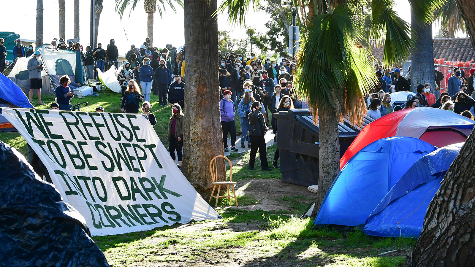 Social activists, homeless residents, and supporters rally at the start of a 24-hour vigil to block a planned shutdown of a homeless encampment at Echo Lake Park in Los Angeles