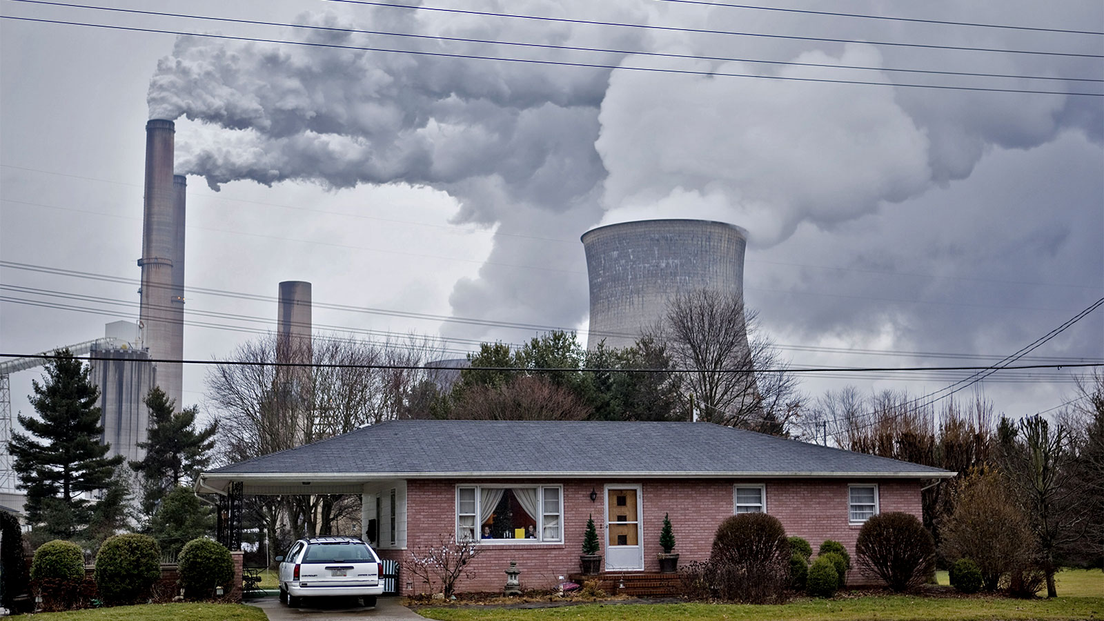 The stacks from the Gavin coal burning power plant dwarf a small nearby home in Cheshire, Ohio
