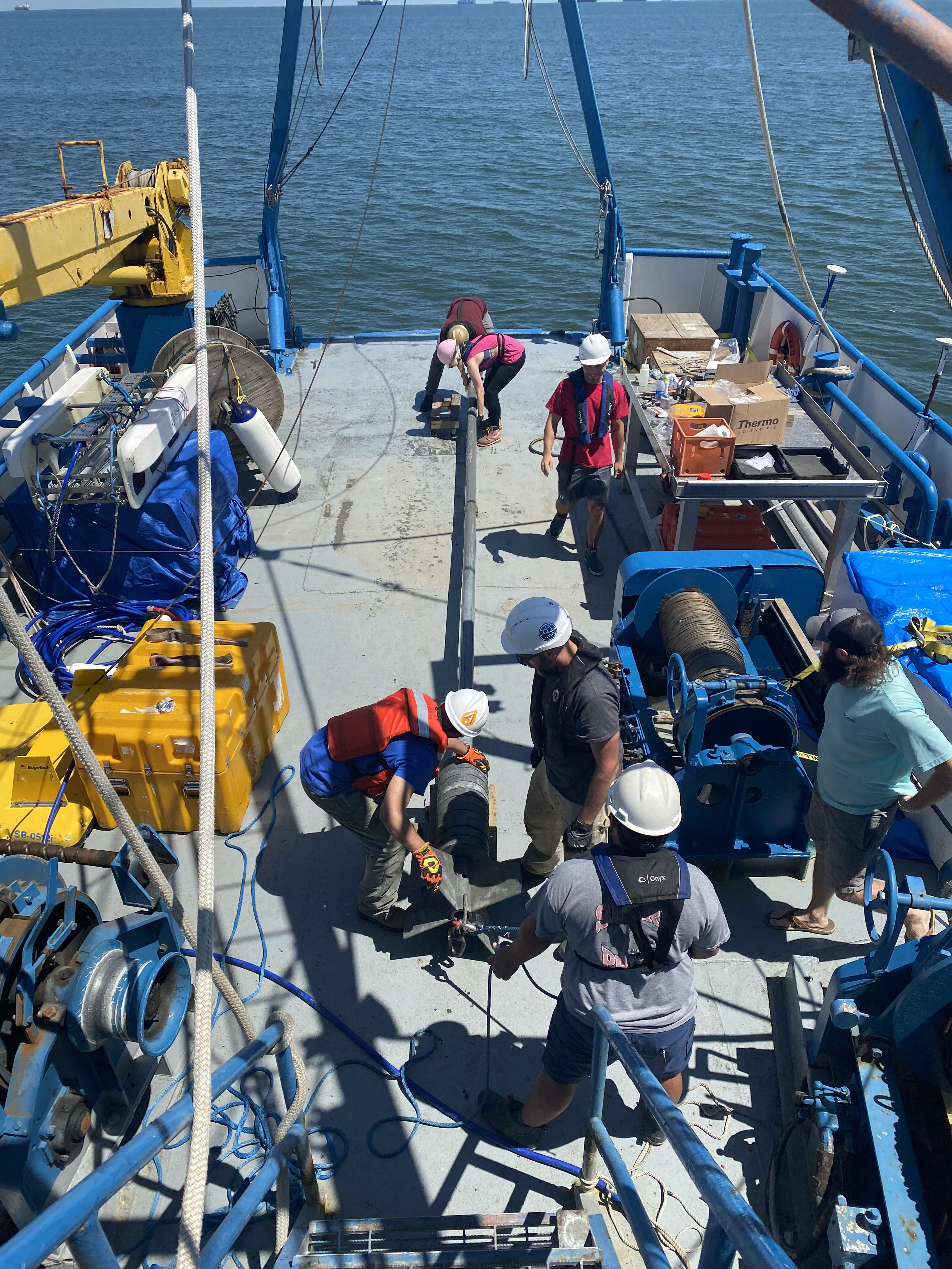 Researchers prepare to lower coring device into the water