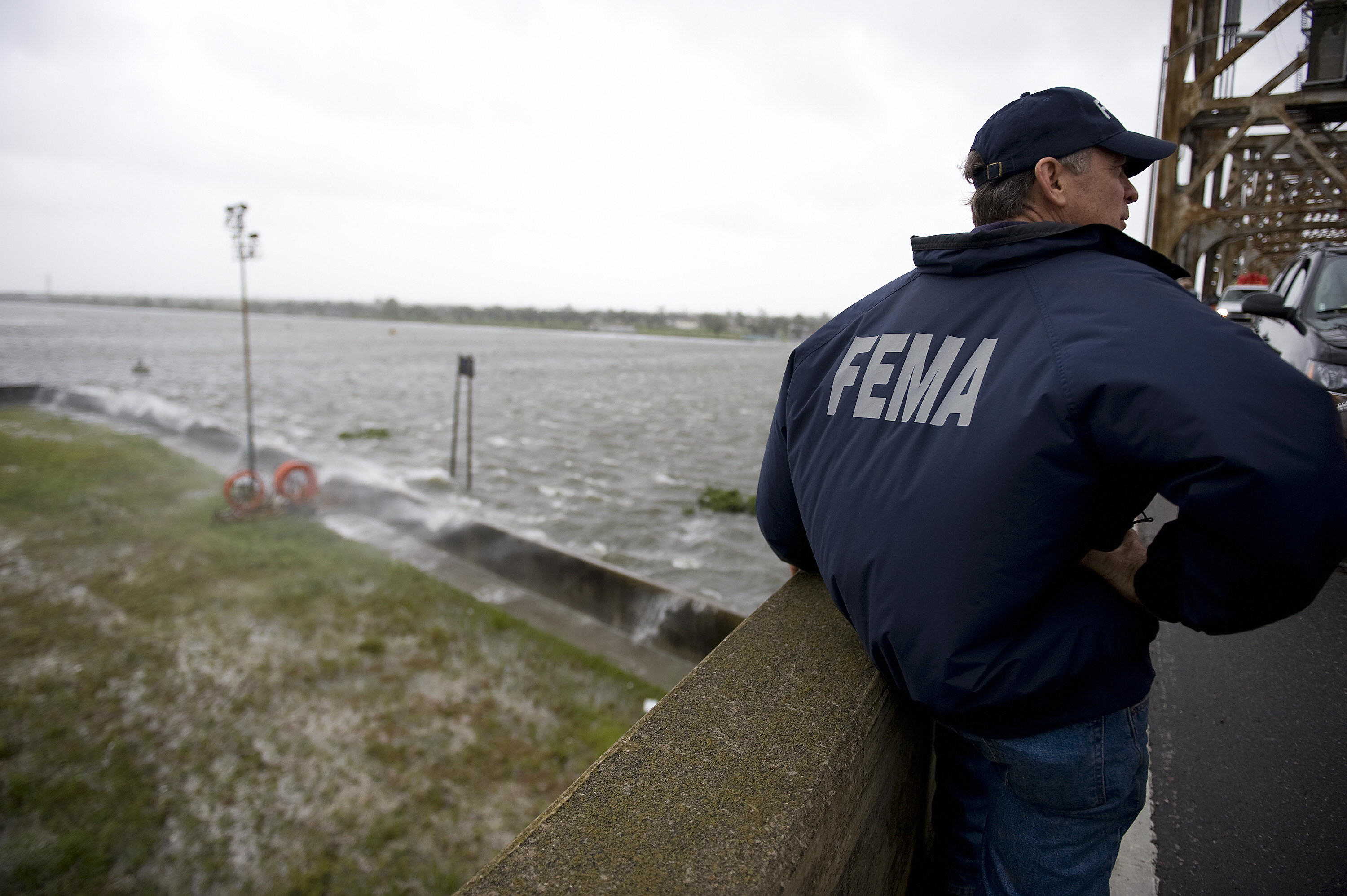 A FEMA representative stands on a bridge in New Orleans surveying the area.