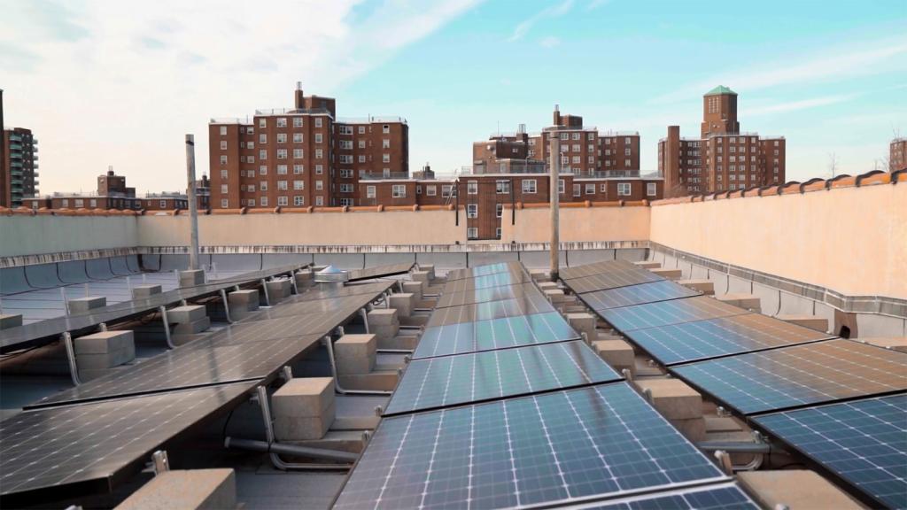 Solar panels on a roof with buildings in the background