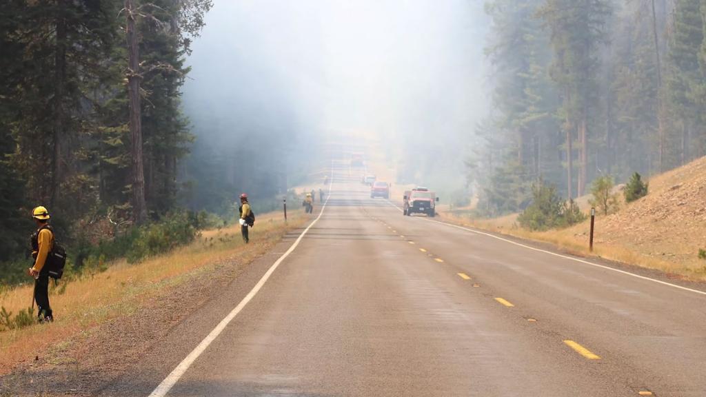 Firefighters alongside a smoke filled road in Washington state