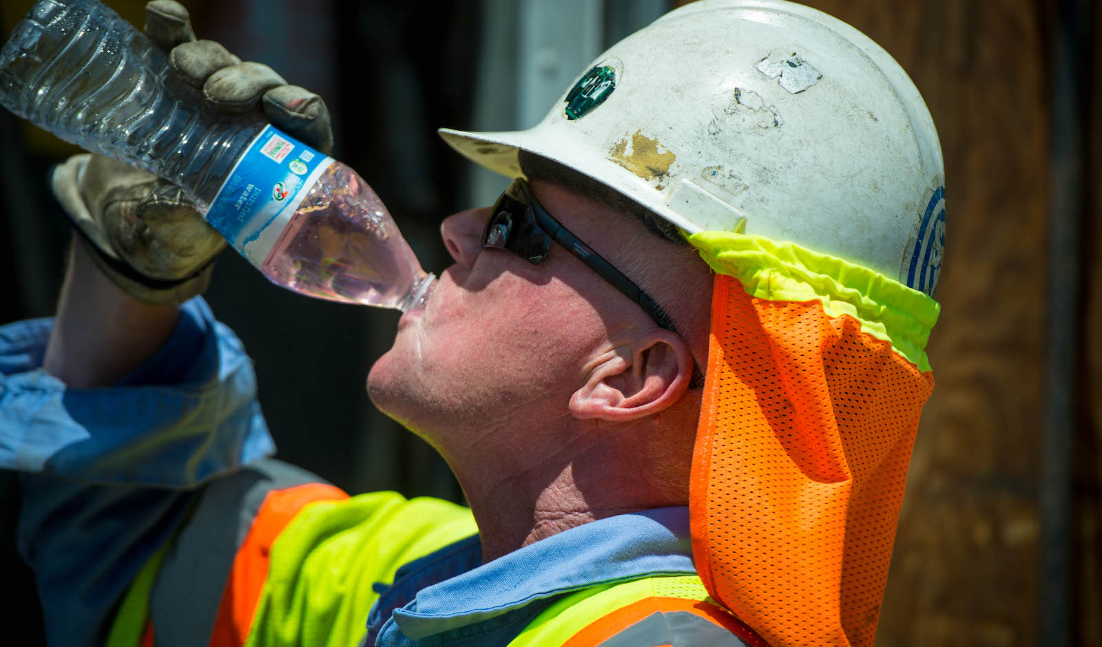Construction worker takes a drink of water on a hot day