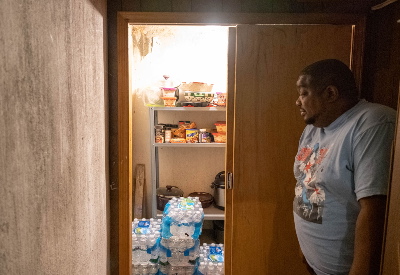 A Flint, Michigan resident looks at his stockpile of bottled water