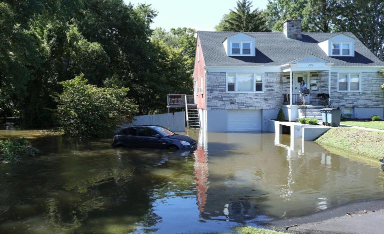 A car sits on a flooded driveway of a house following a night of heavy wind and rain from Hurricane Ida
