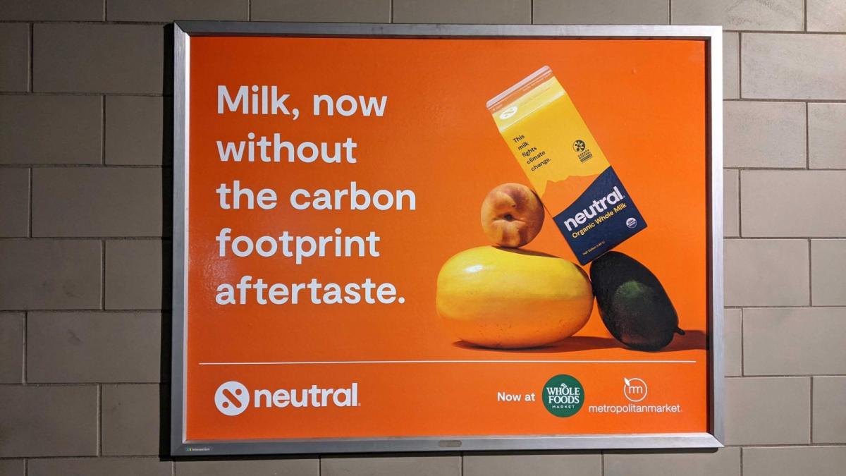 A, orange advertisement says "Milk, now without the carbon footprint aftertaste."