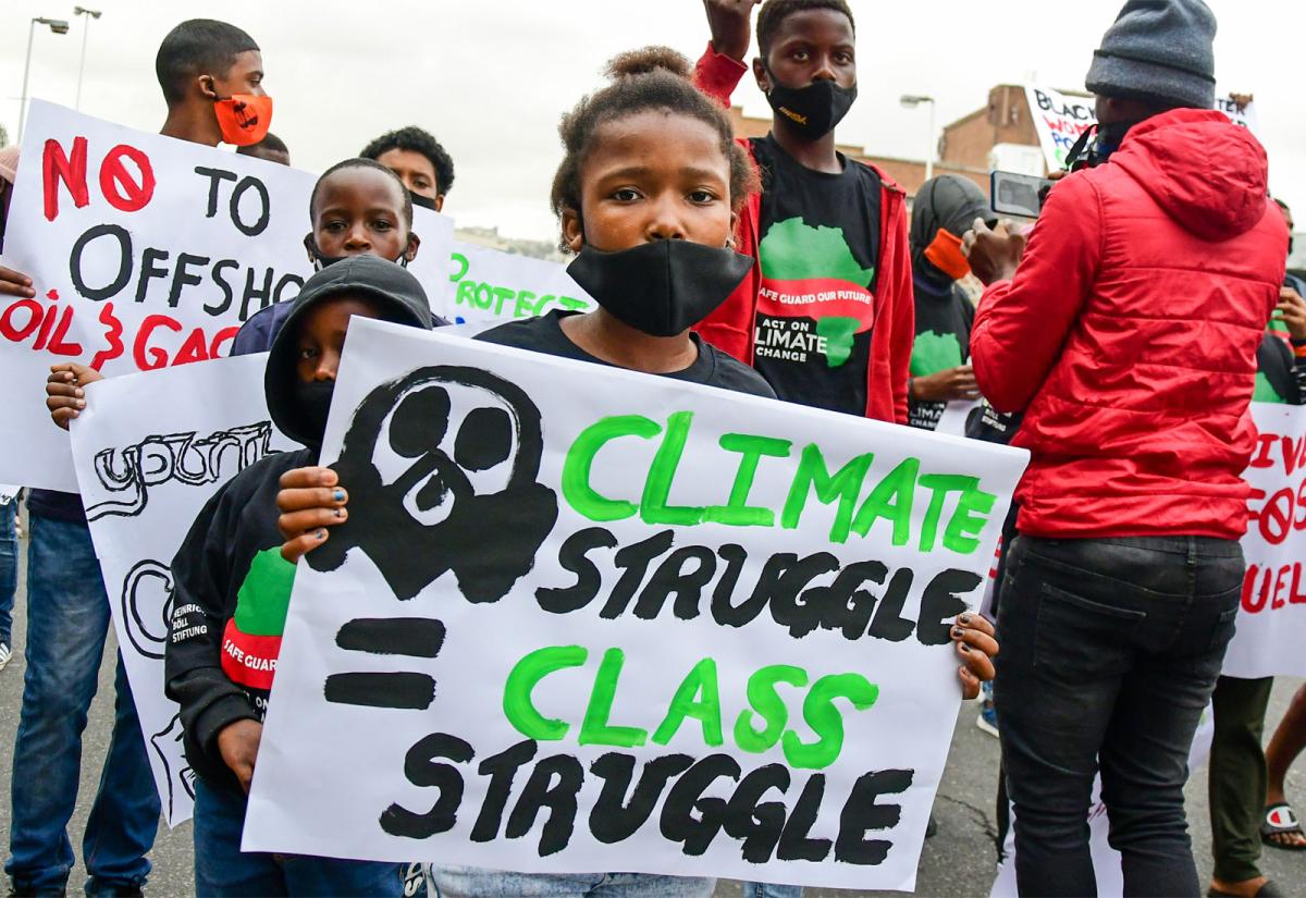 A young girl at a climate protest holding a sign that reads "Climate struggle=class struggle"