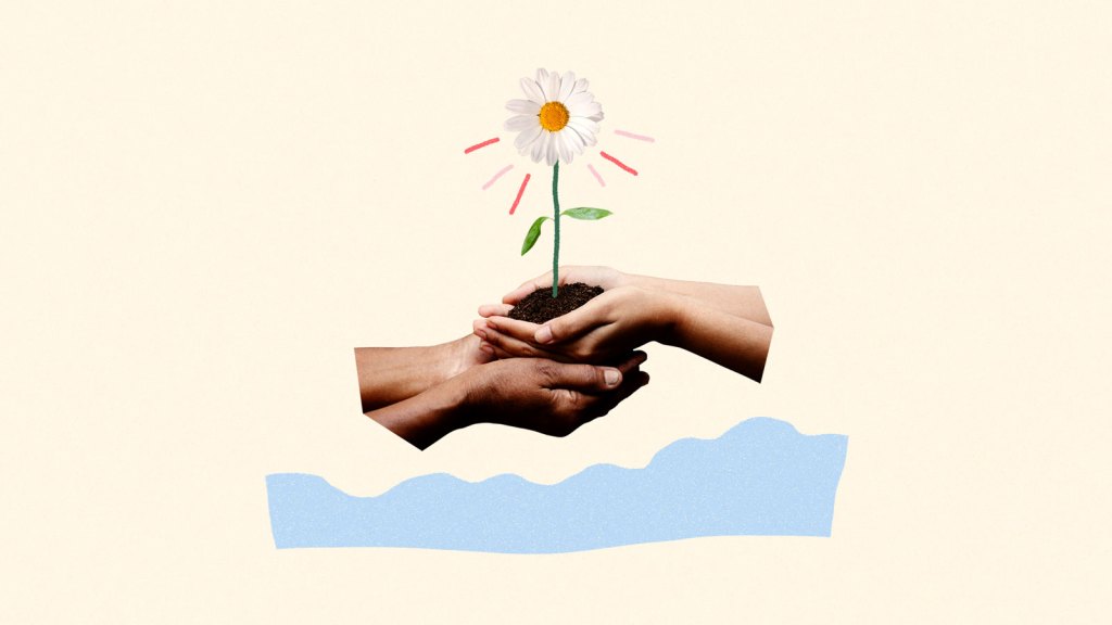 Hands holding flower above flood water