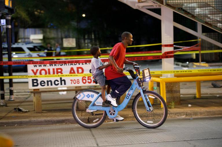 A man and child ride on a bike in Chicago.