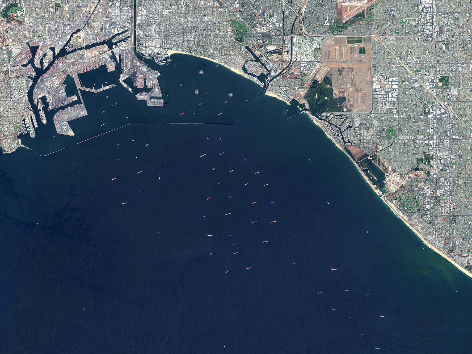 a satellite view of the port of Los Angeles with many cargo ships out at sea