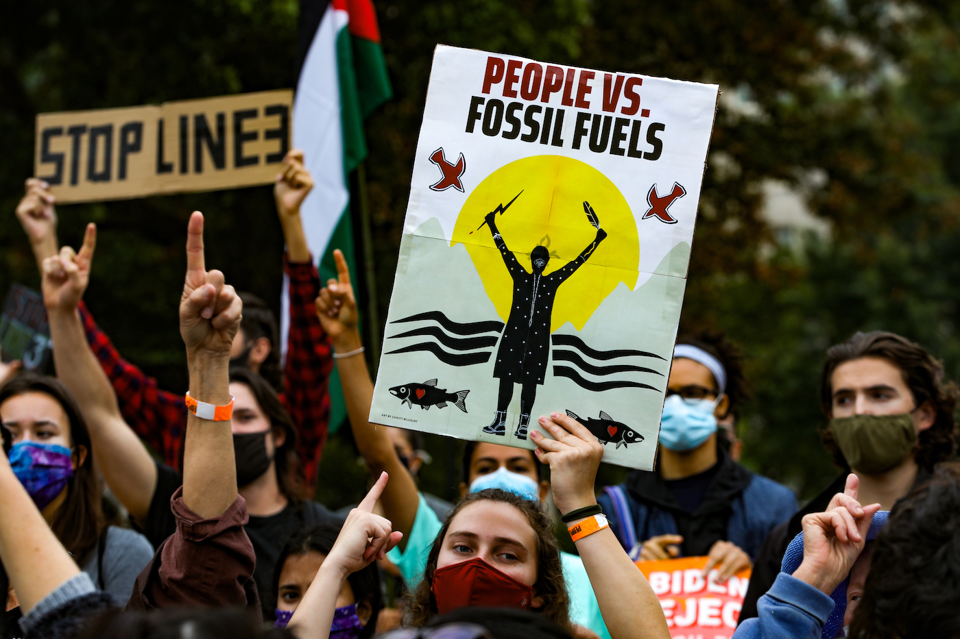 Protesters hold signs that say "Stop Line 3" and "People Vs. Fossil Fuels."
