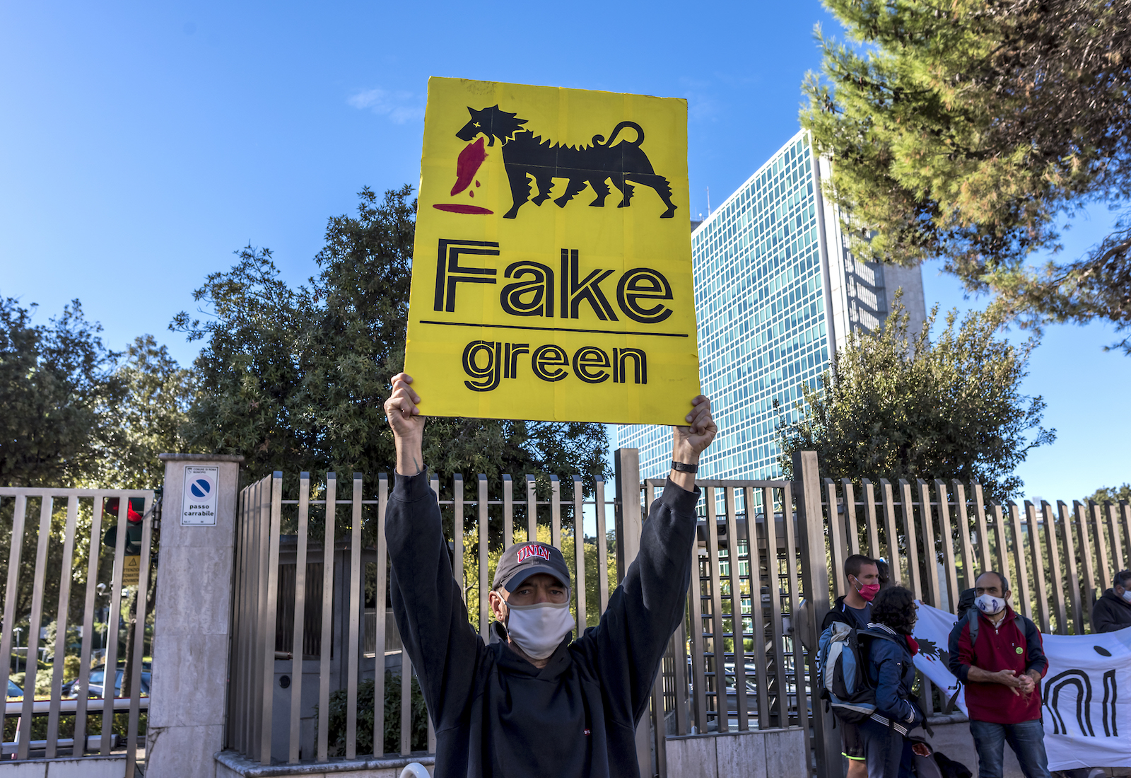 A man protests the energy company Eni as "Fake green."